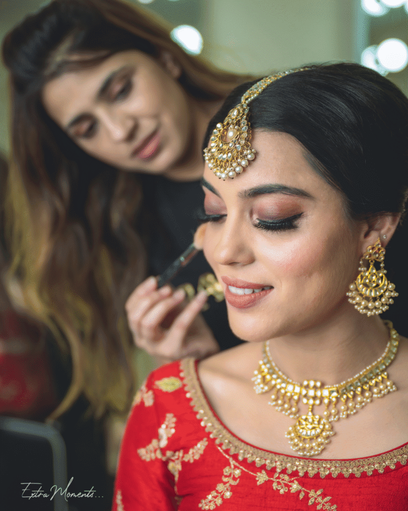 bride smiling while getting her makeup done for her wedding